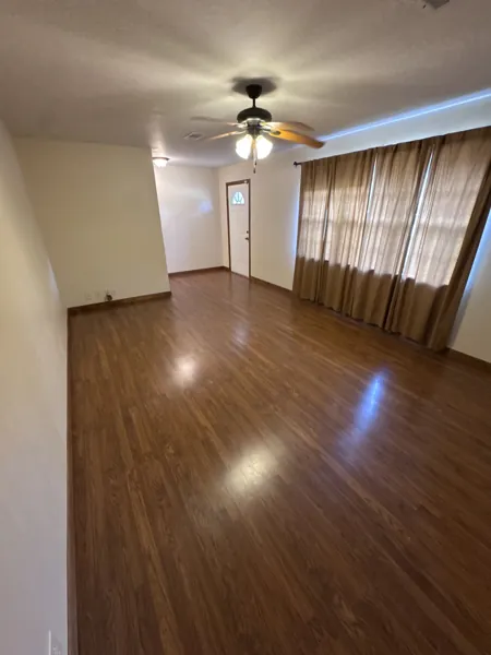 Living room with wood-look flooring and front windows